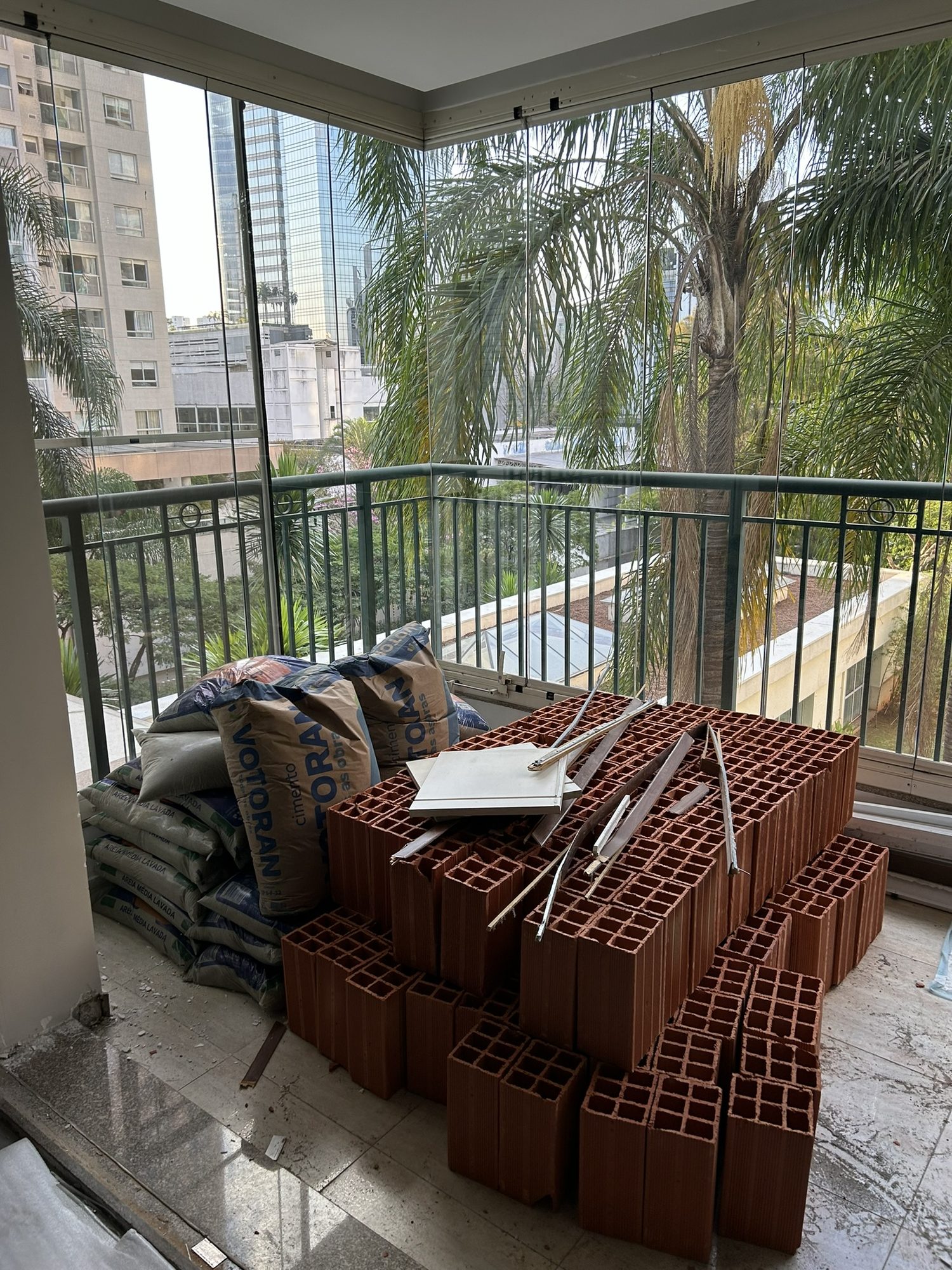 Obra do apartamento PW em andamento, com materiais na varanda